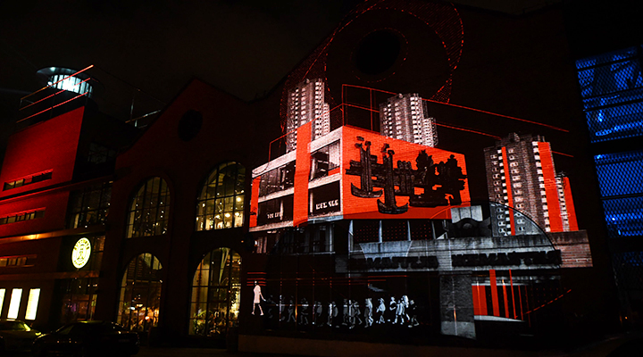 Light projection on Klaipeda’s brewery wall featuring animated cityscape and maritime symbols for the 700th anniversary celebration.